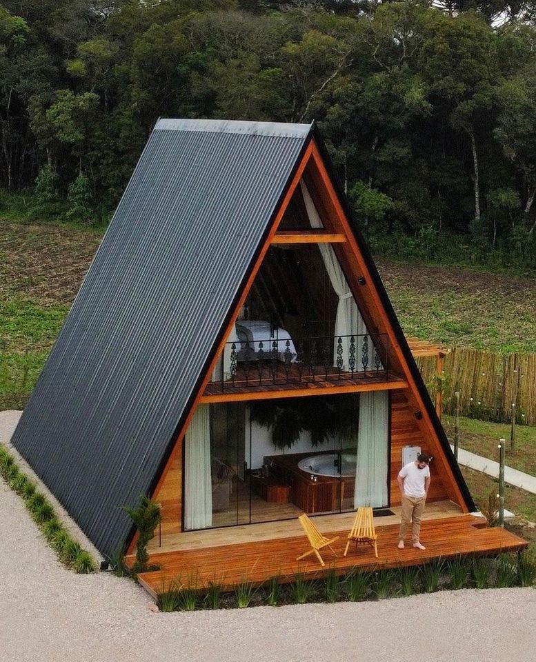 The meme is a picture of the "A-Frame" cabin, a small, triangular-shaped house. The image is captioned "I love my tiny home, I can fit my entire family in the loft". The meme is likely used to poke fun at the idea of a small, cozy home being able to fit a large family, implying that the family is actually quite small.